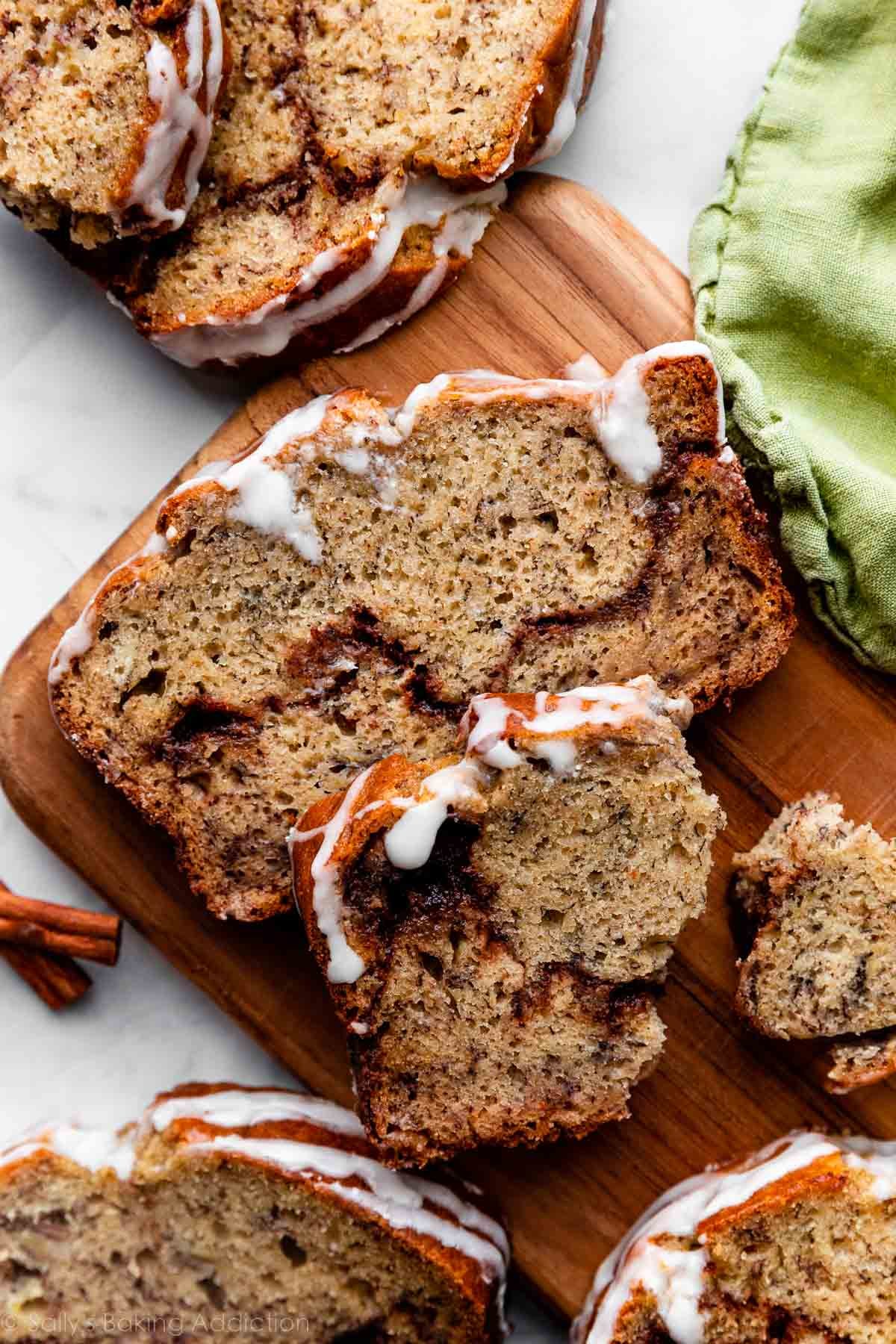 cinnamon swirl banana bread slices on wooden loaf cutting board.