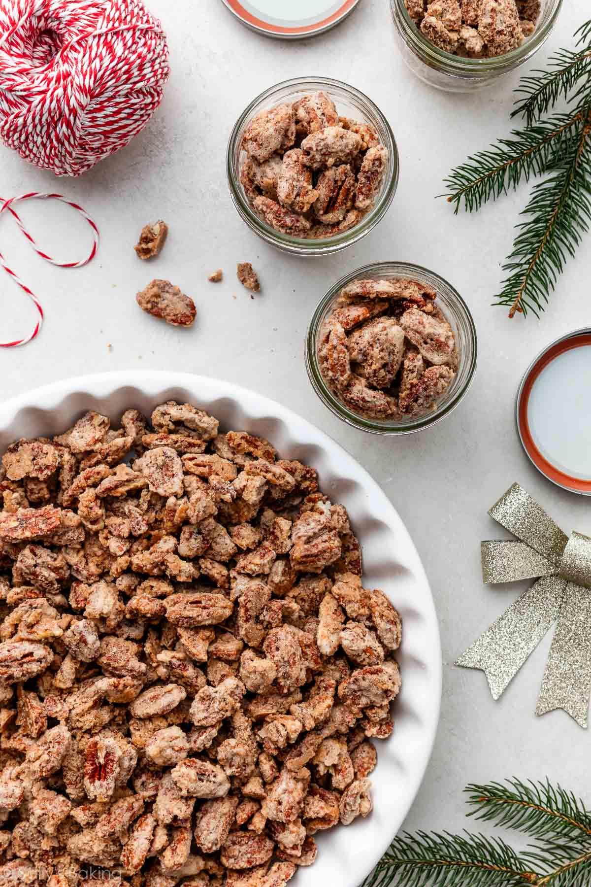 candied pecans in large white dish and also pictured in jars.