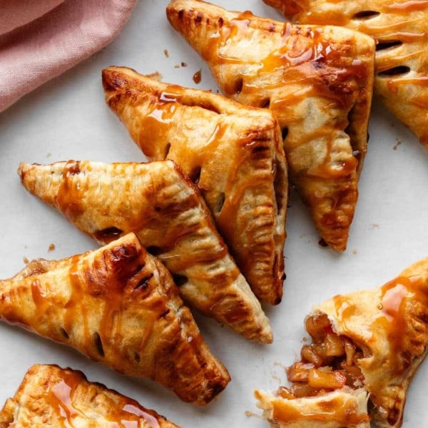 apple turnovers with caramel sauce on top in a diagonal line.