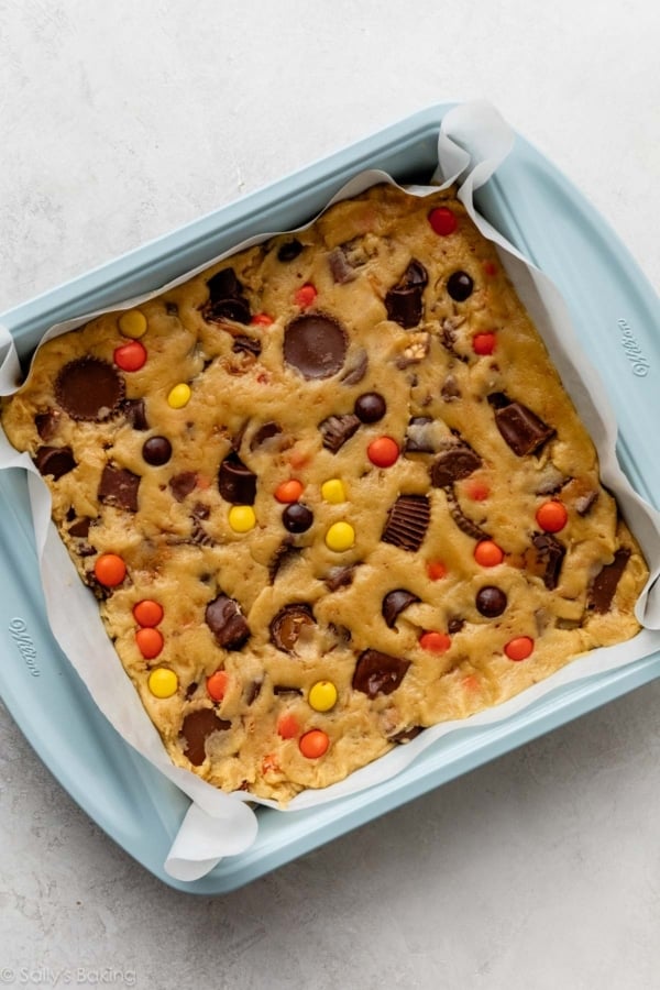 blondie batter in lined blue square baking pan.