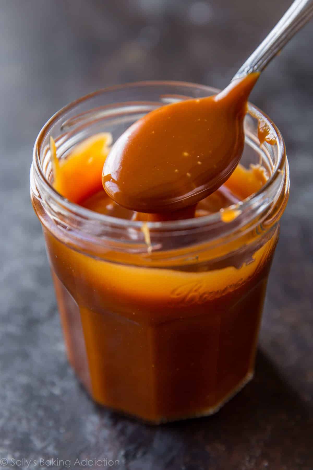 Salted caramel in a glass jar with a spoon