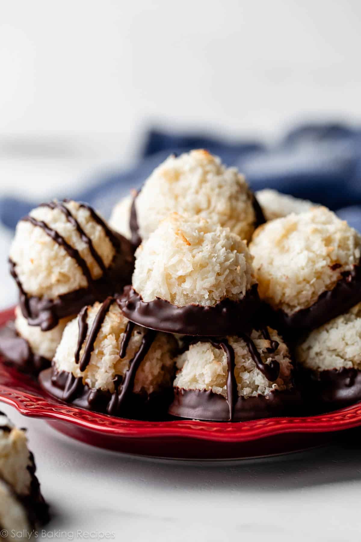 red plate with chocolate dipped coconut macaroons.