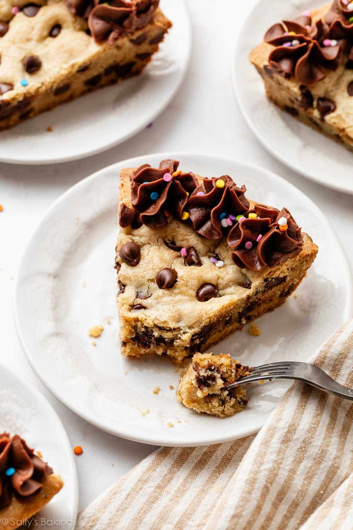 slices of chocolate chip cookie cake on white plates.