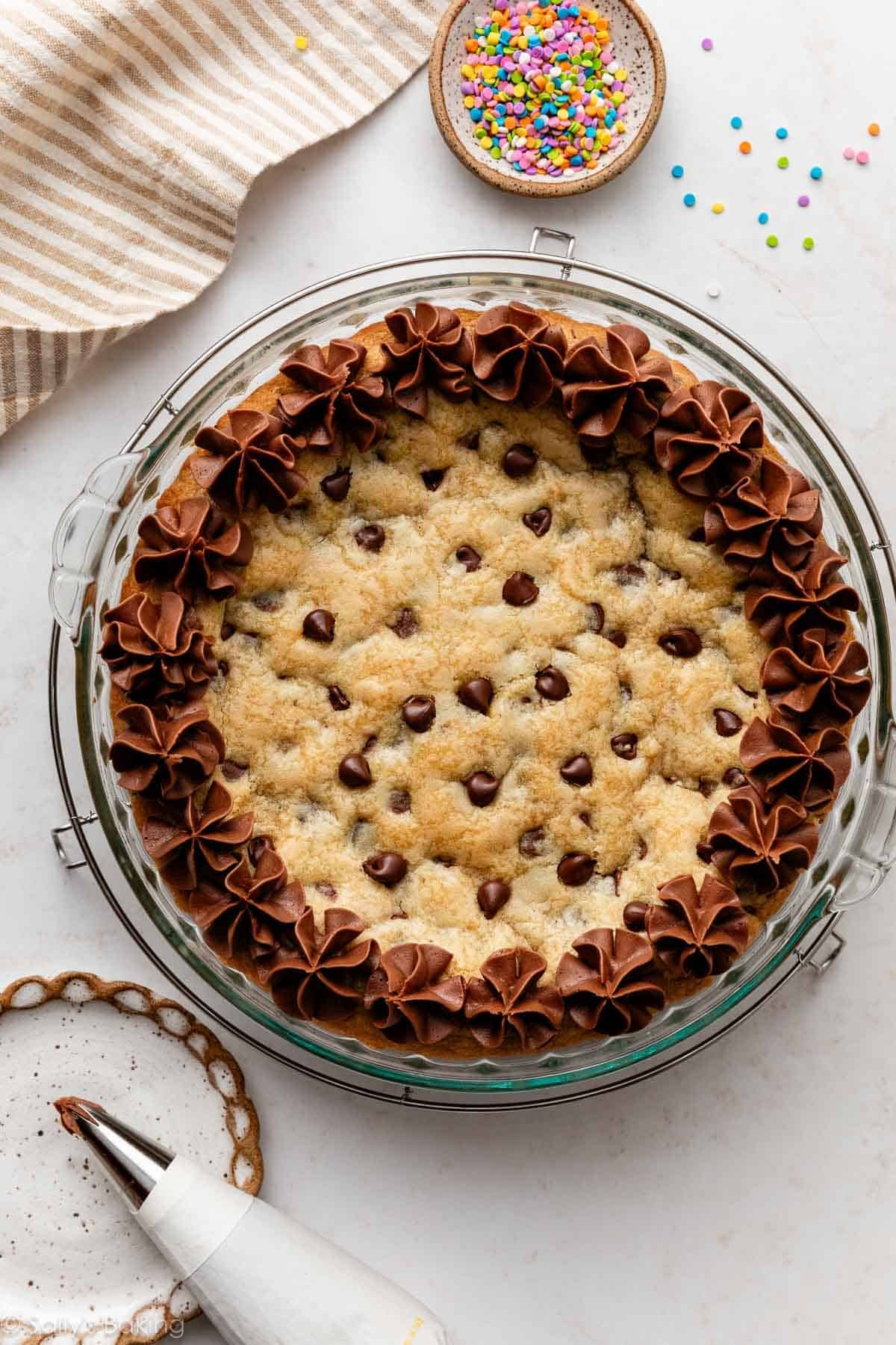 chocolate chip cookie cake with piped chocolate buttercream border.
