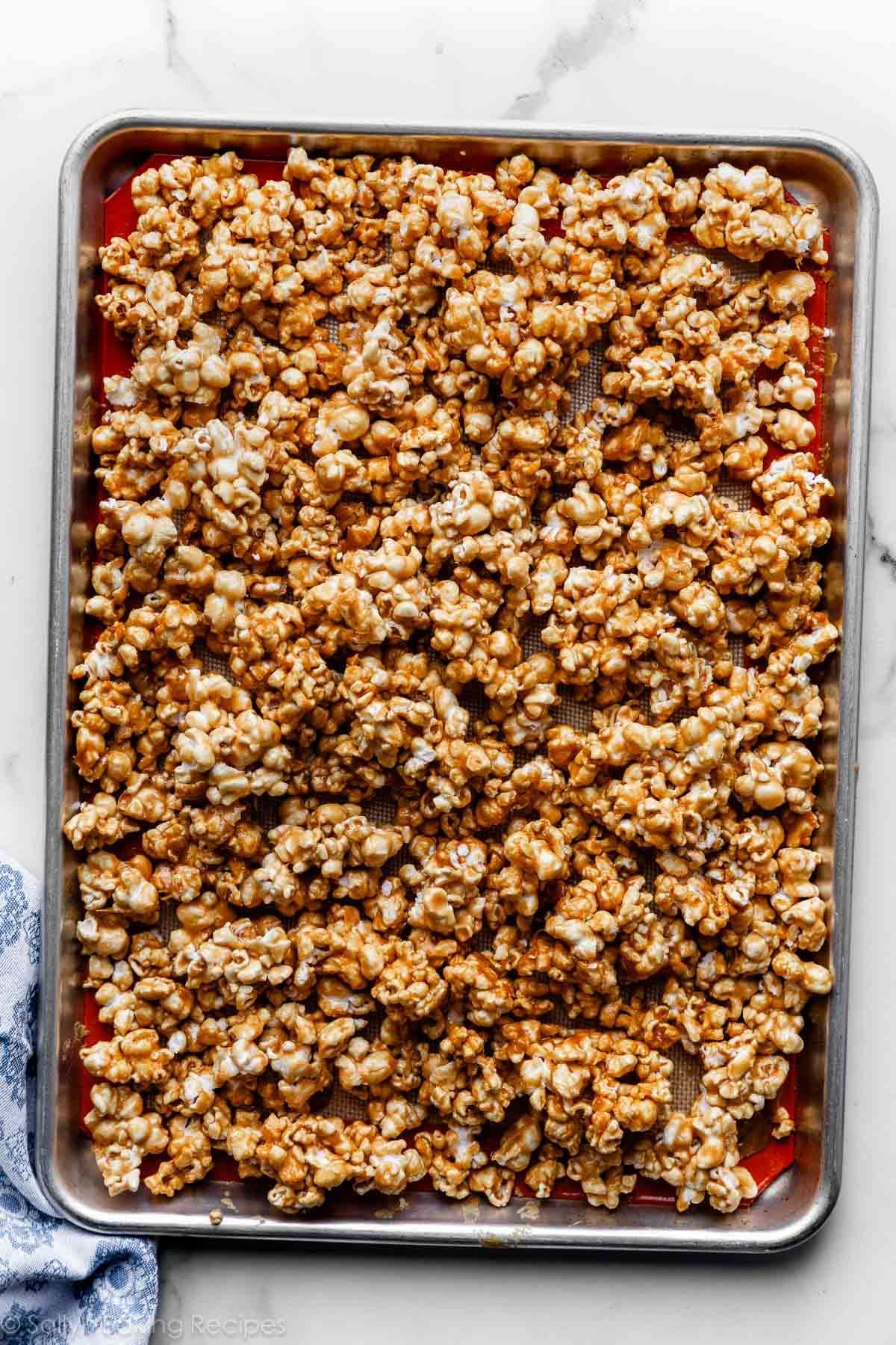 caramel corn spread on lined baking sheet.