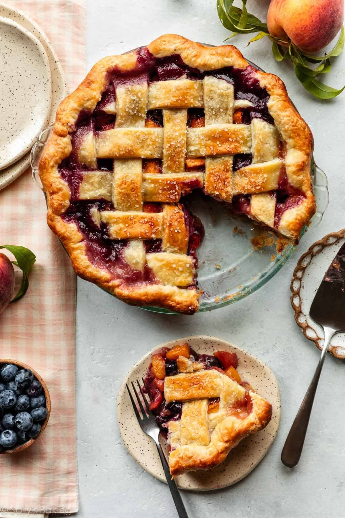 blueberry peach pie with lattice top with slice taken out.