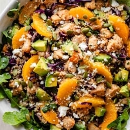 citrus chicken quinoa salad over arugula greens.