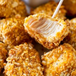 pretzel crusted chicken bites on a white plate