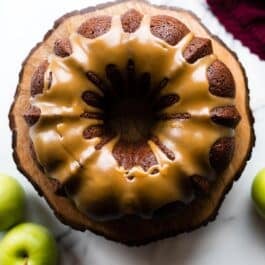 overhead image of apple bundt cake on a wood slice cake stand
