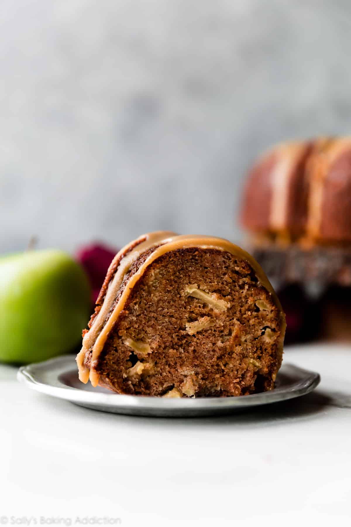 slice of glazed apple bundt cake on a silver plate