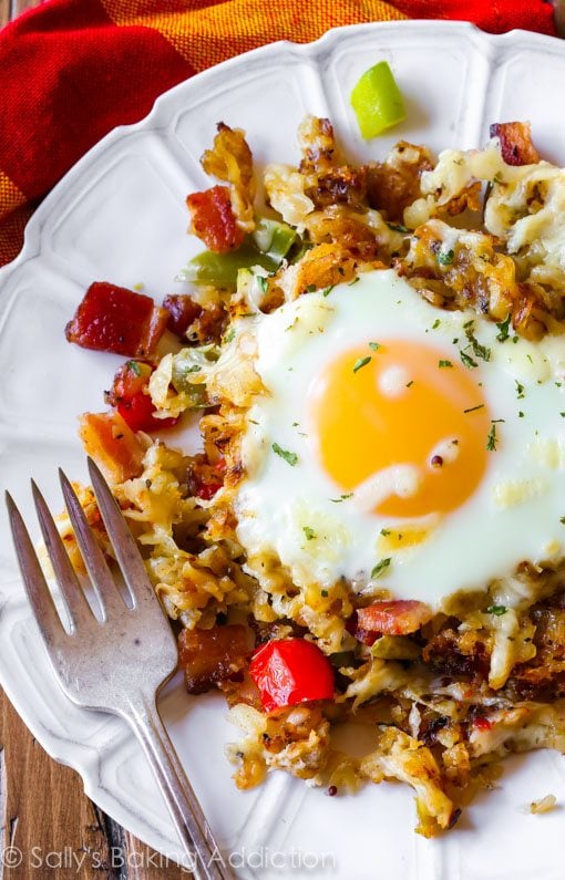 overhead image of crispy hash breakfast skillet on a white plate with a fork
