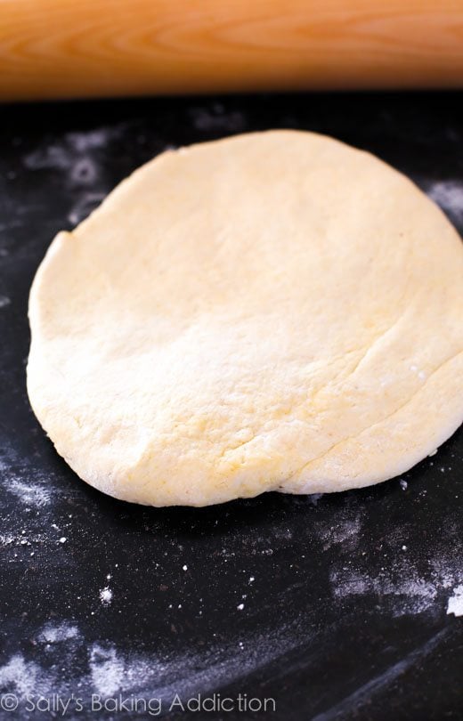 pizza dough with a wood rolling pin