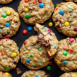 overhead image of monster cookies with one cookie broken in half showing a peanut butter cup inside