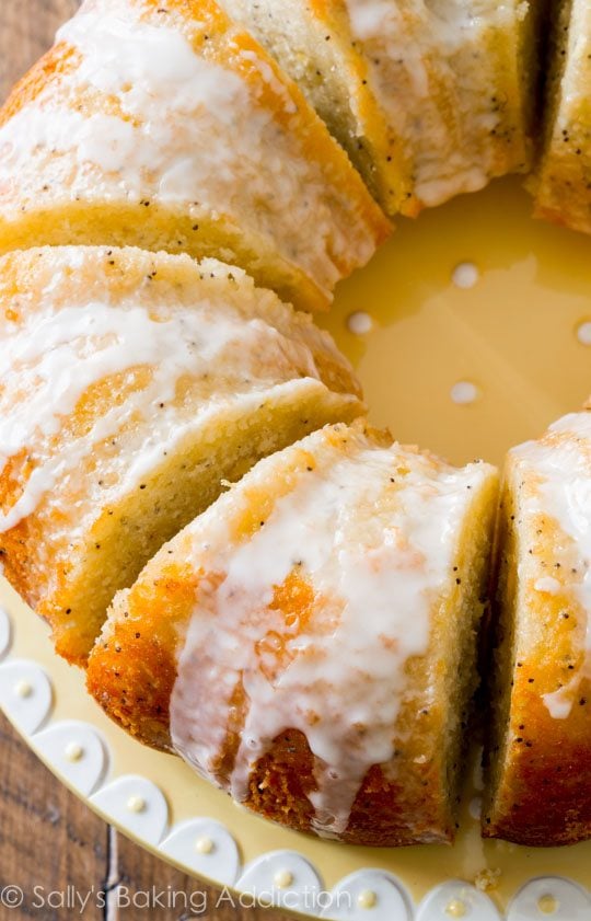 overhead image of lemon poppy seed bundt cake cut into slices on a yellow plate
