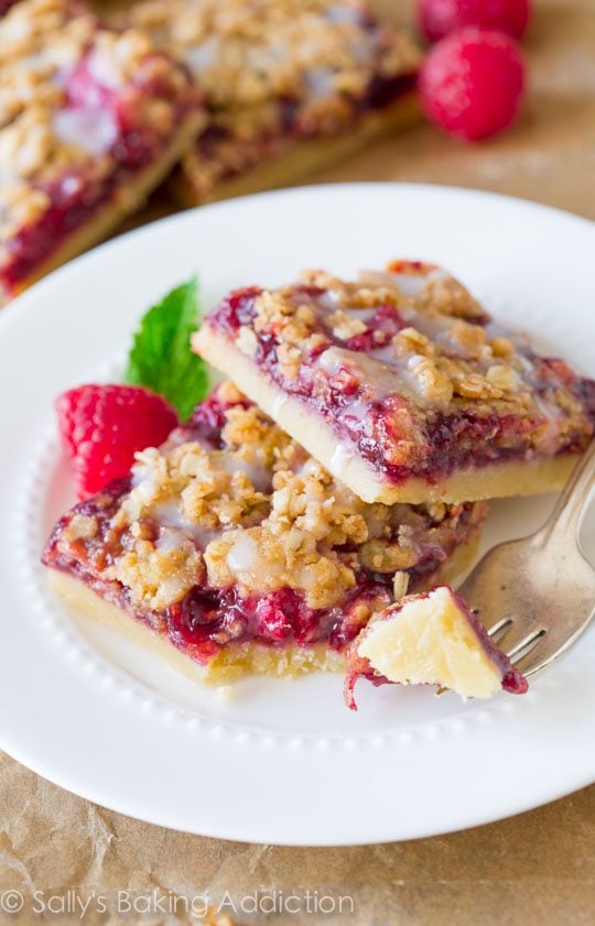 raspberry streusel bars on a white plate with a fork