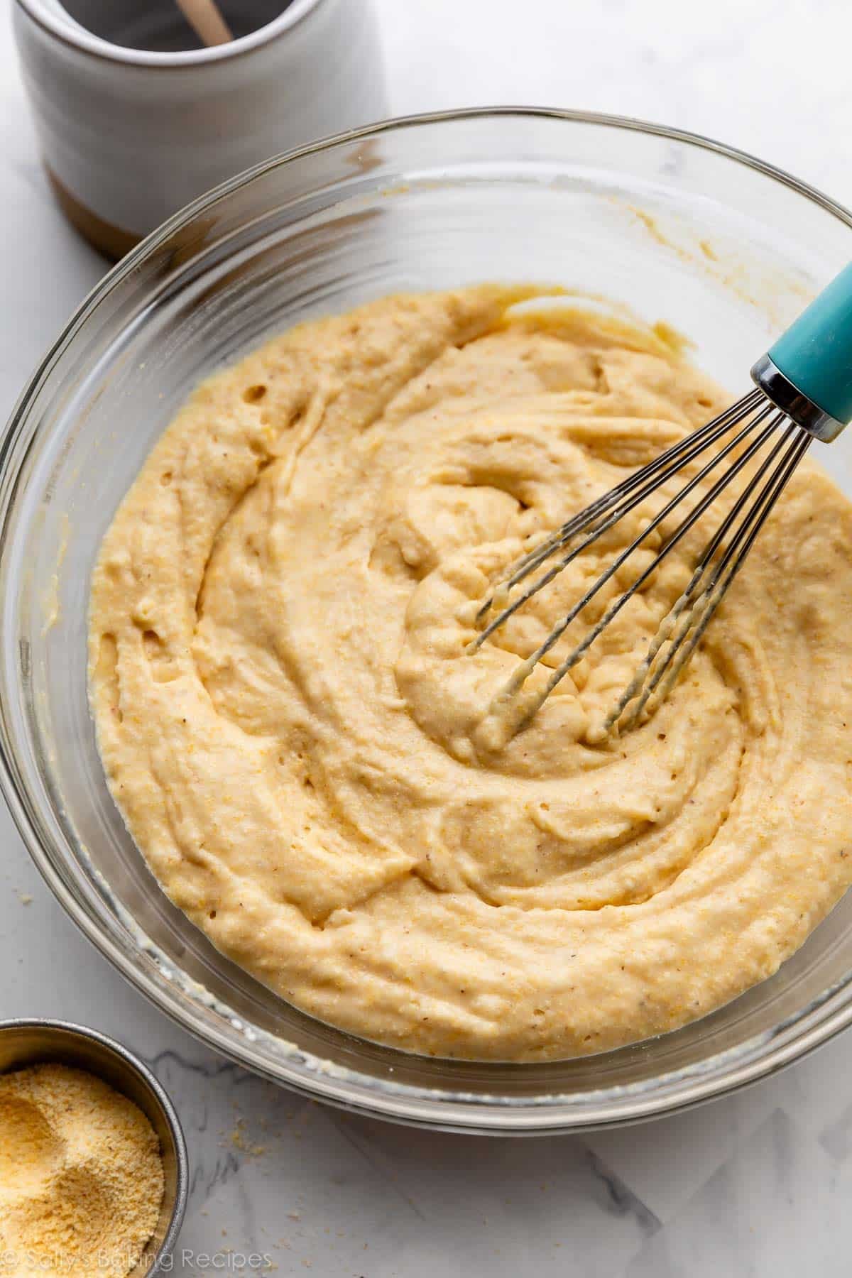batter in glass bowl with blue whisk.