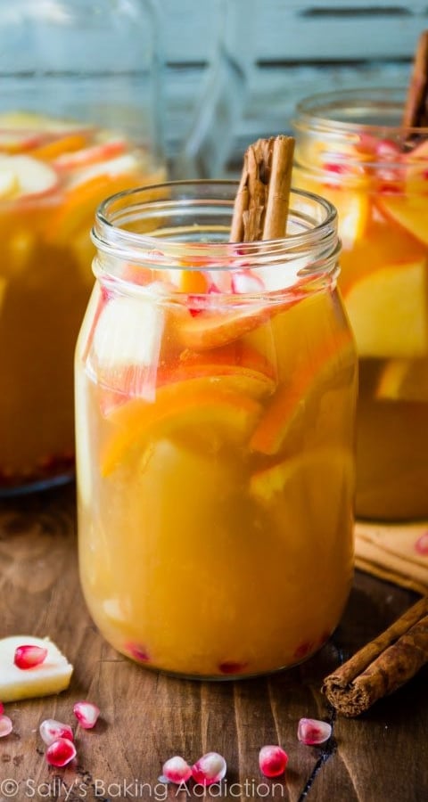 apple cider sangria in a glass with cinnamon sticks