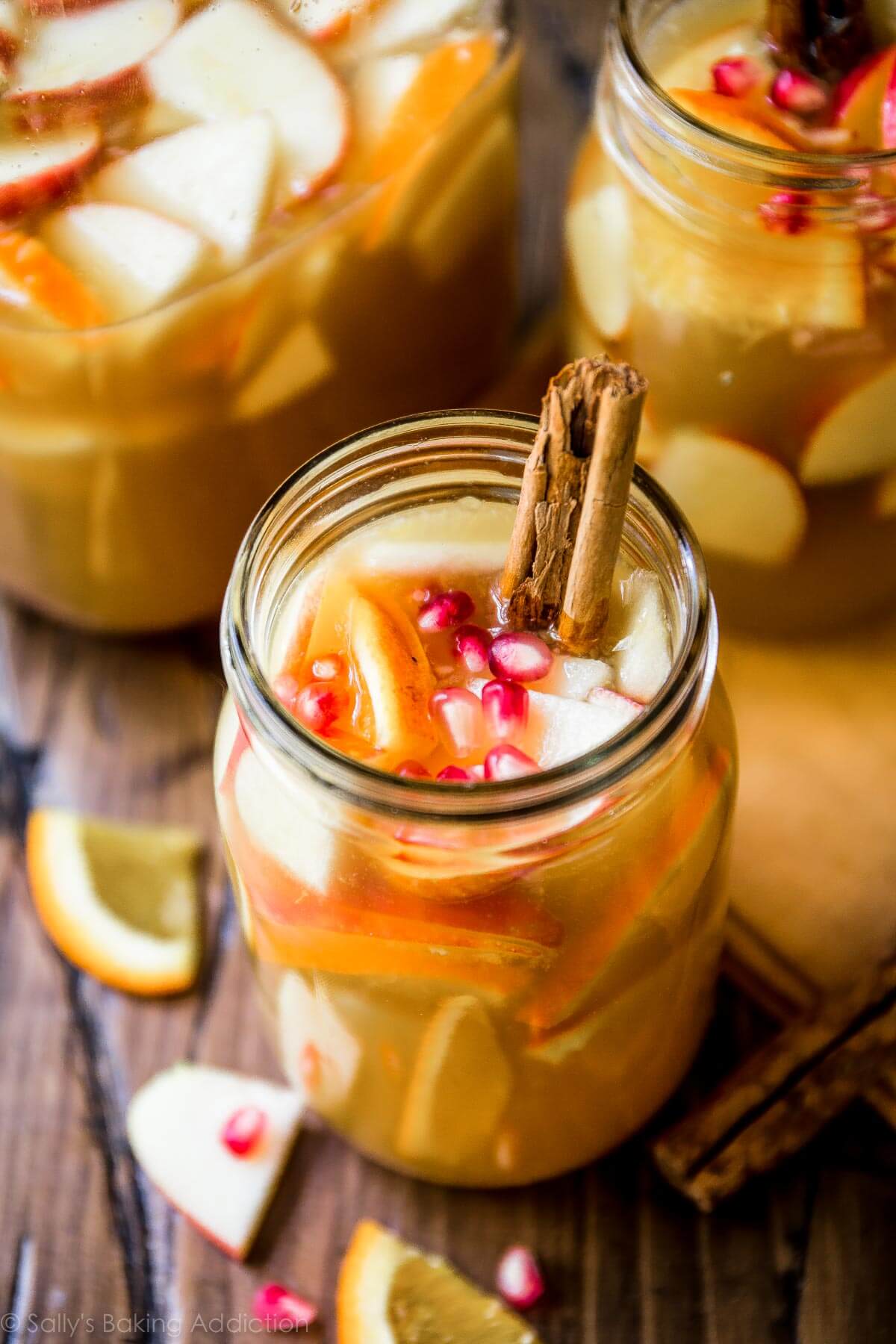 apple cider sangria in glass jars with cinnamon sticks