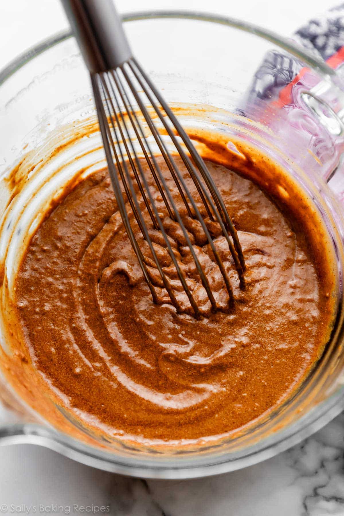 molasses batter in glass bowl with wire whisk.