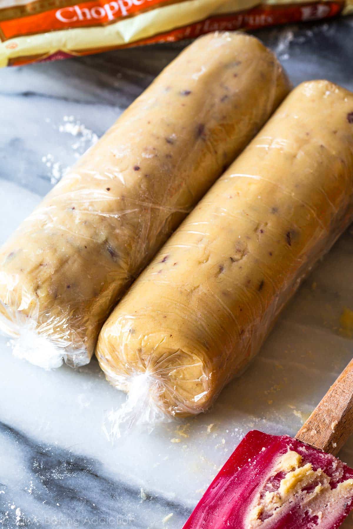 2 logs of cookie dough wrapped in plastic wrap on the counter