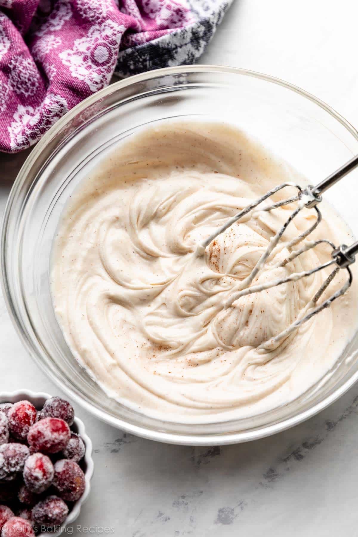 spiced cream cheese frosting in glass bowl with hand beaters.