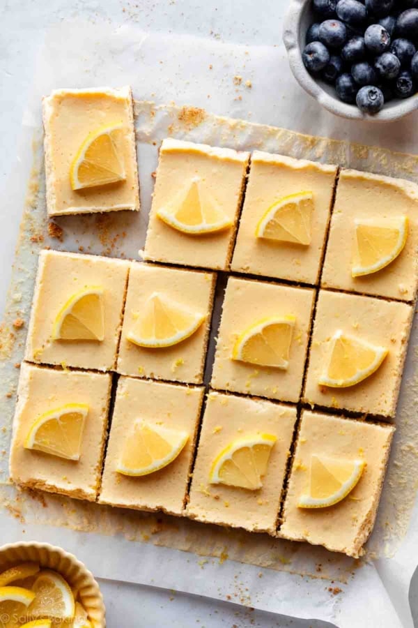 cut lemon Greek yogurt bars on parchment paper with lemon slices on each.