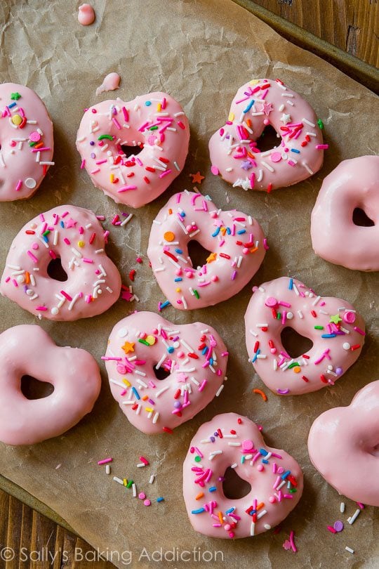 heart shaped donuts topped with pink glaze and sprinkles
