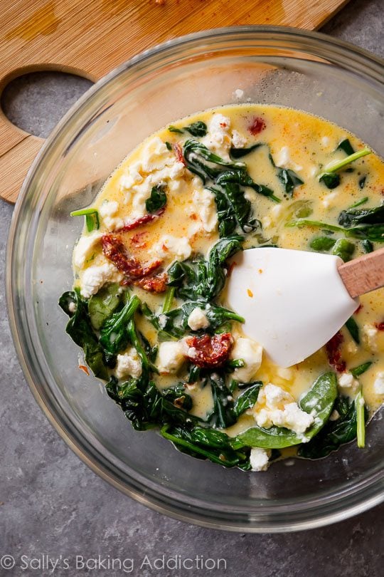 filling for goat cheese spinach sun-dried tomato quiche in a glass bowl