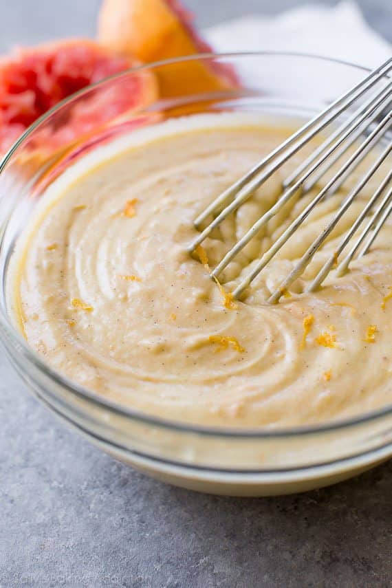 grapefruit Greek yogurt cake batter in a glass bowl with a whisk
