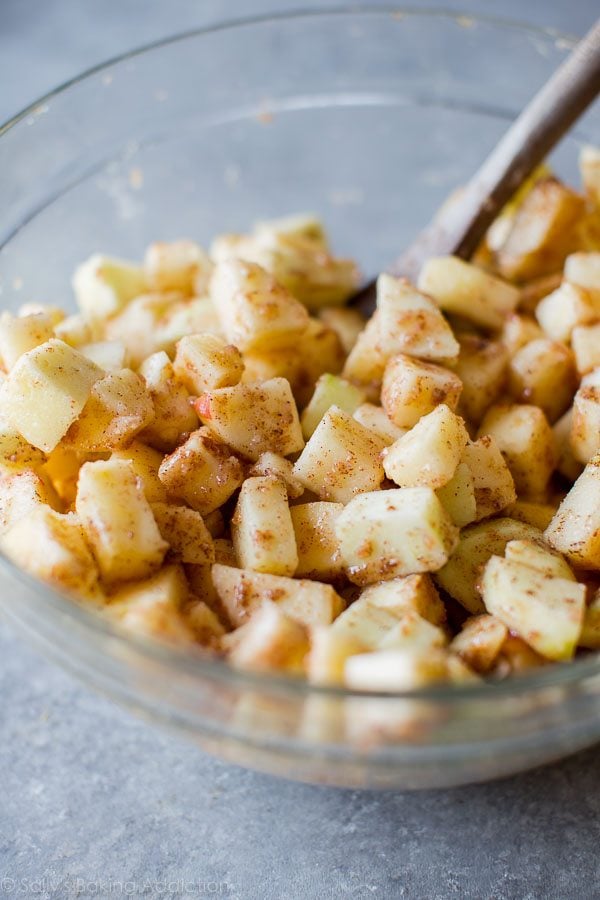 apple slab pie filling in a glass bowl with wood spoon