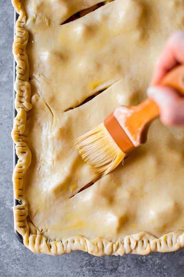 brushing egg wash onto slab pie crust