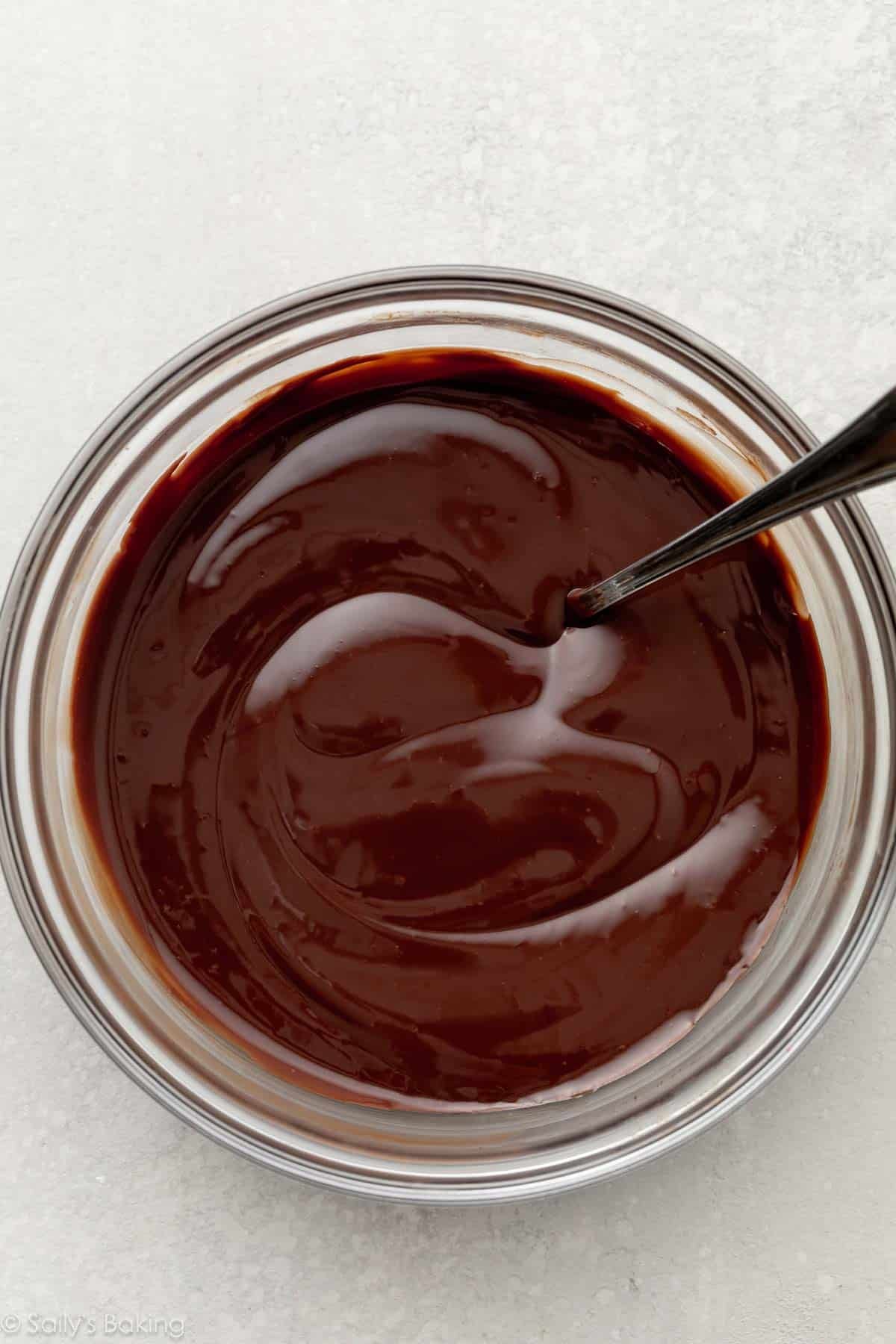 smooth chocolate ganache with spoon in small bowl.