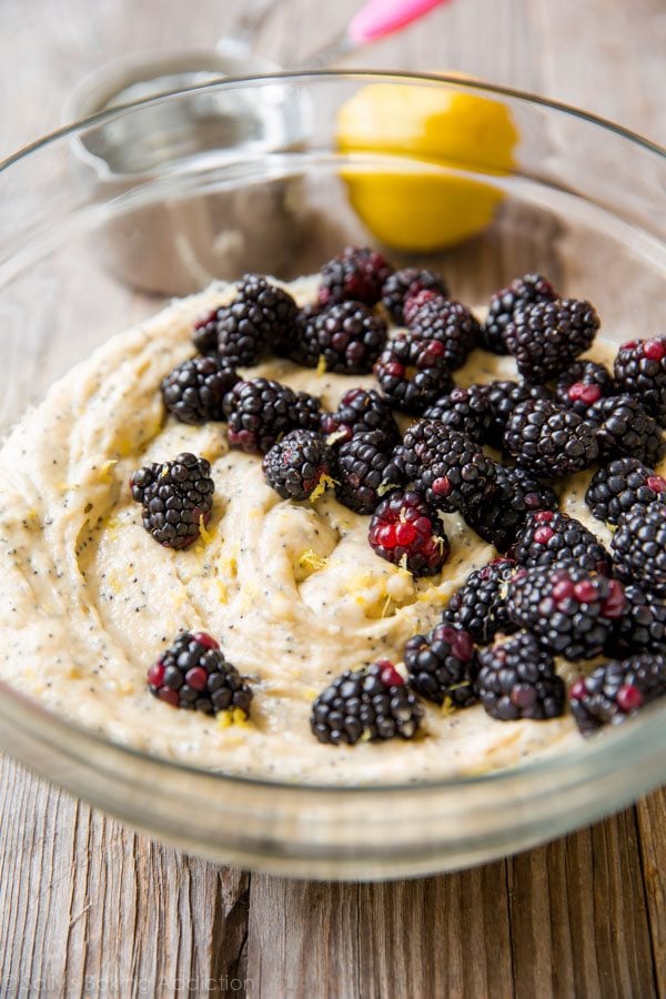 blackberry lemon poppy seed muffin batter in a glass bowl