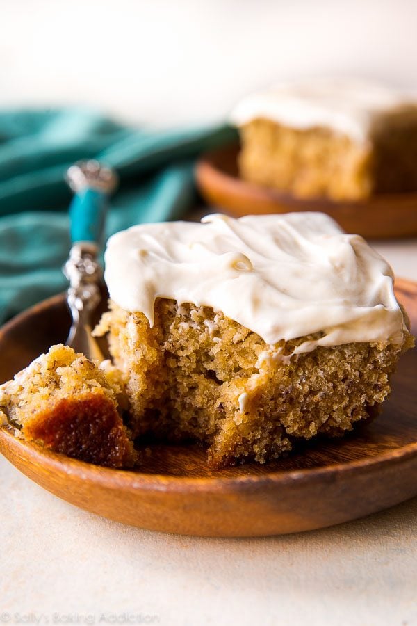 slice of banana cake on a wood plate with a fork