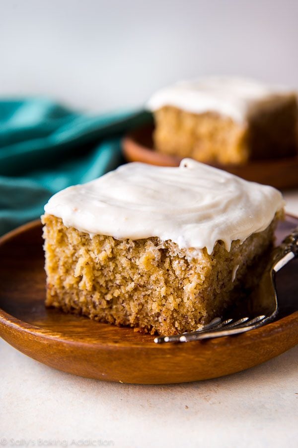 slice of banana cake on a wood plate with a fork