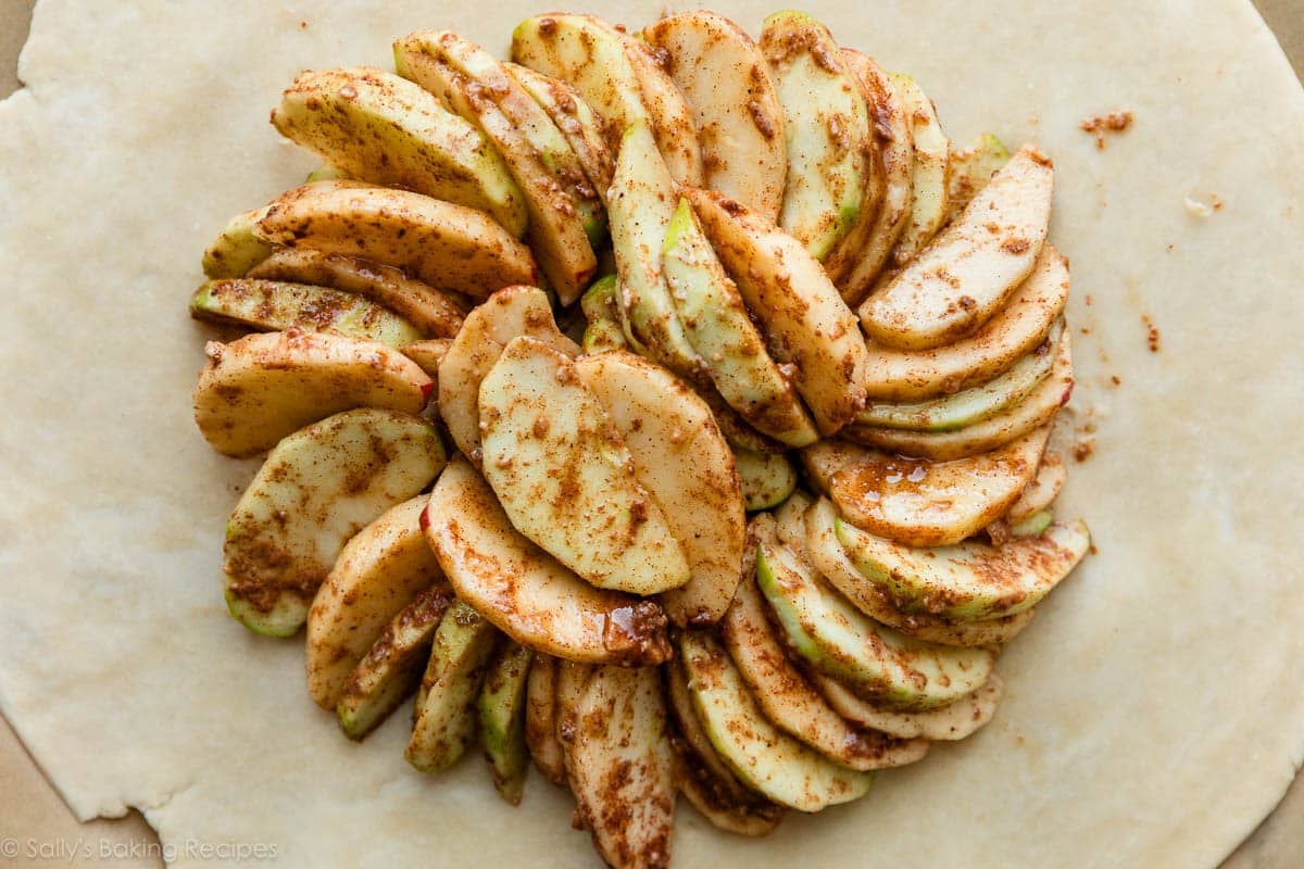 cinnamon apples arranged on dough.