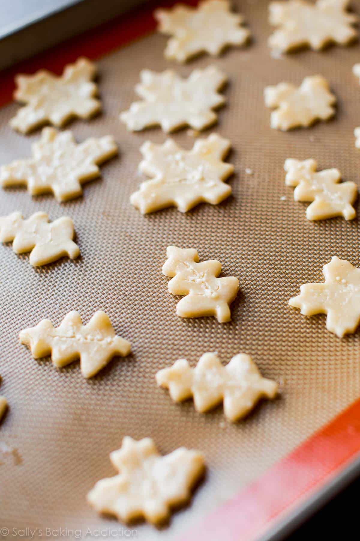 pie crust leaves on a silpat baking mat on a baking sheet before baking