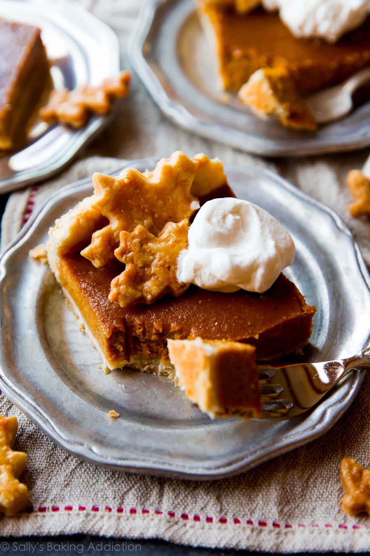 slice of pumpkin slab pie with whipped cream on a silver plate with a fork