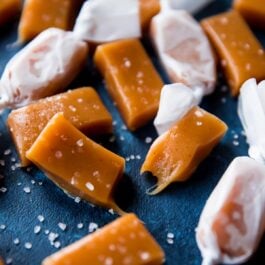 sea salt vanilla caramels cut into small rectangles with some wrapped in candy wrappers
