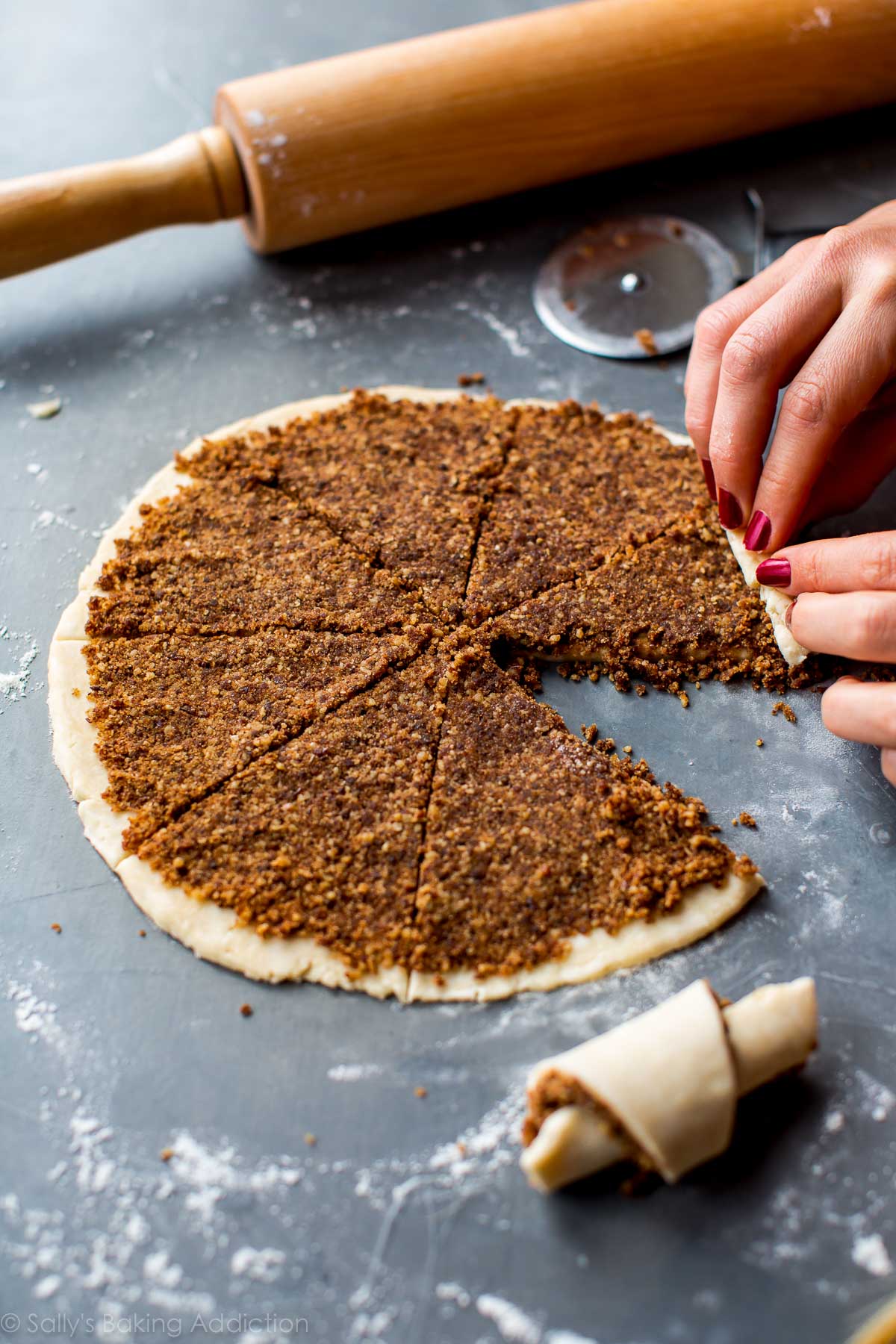 hands rolling up triangles of rugelach cookie dough