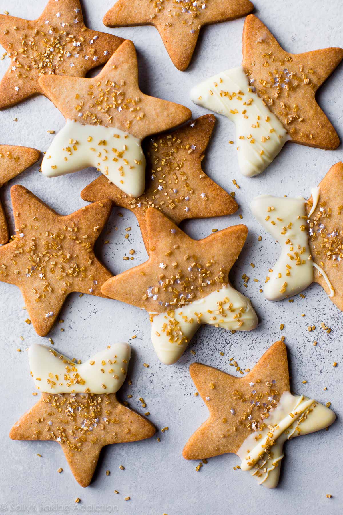 star shaped maple sugar cookies with half of each cookie dipped into white chocolate and topped with sprinkles
