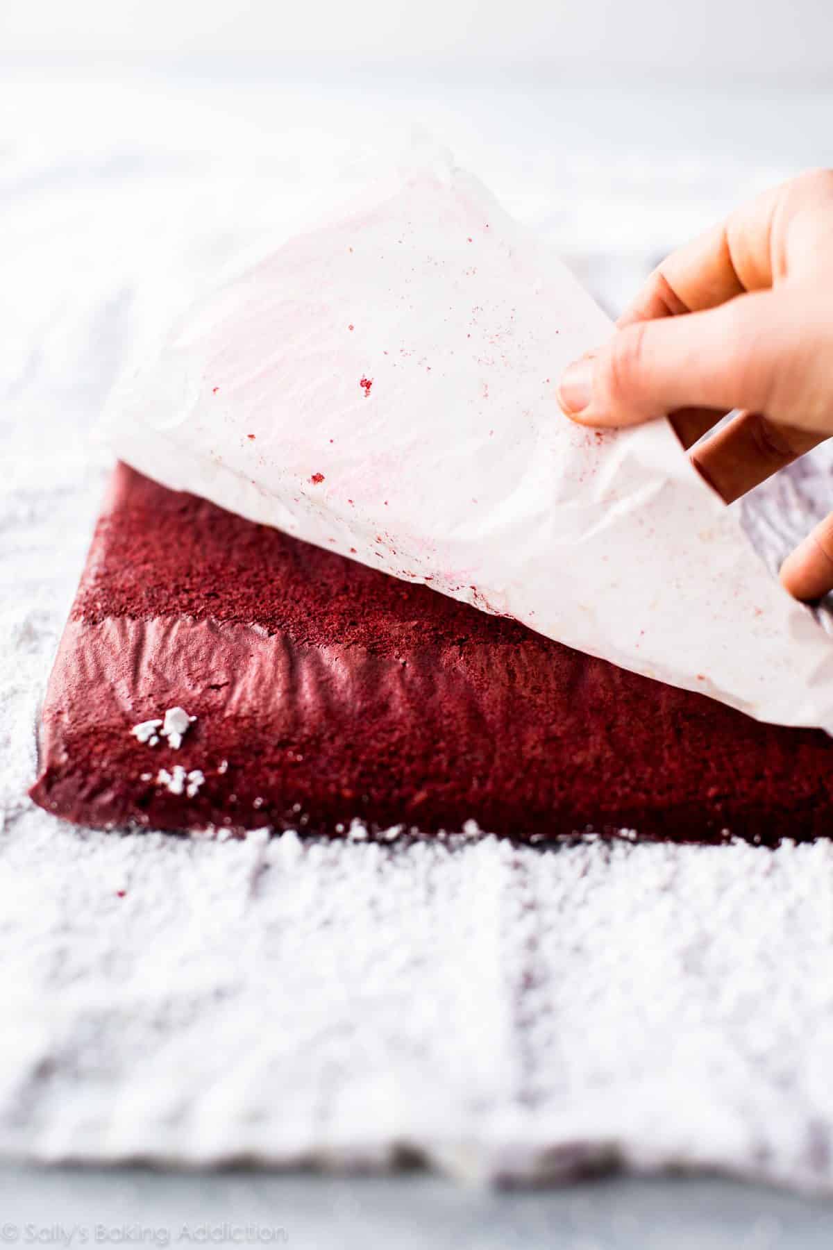 peeling parchment paper off of red velvet sponge cake