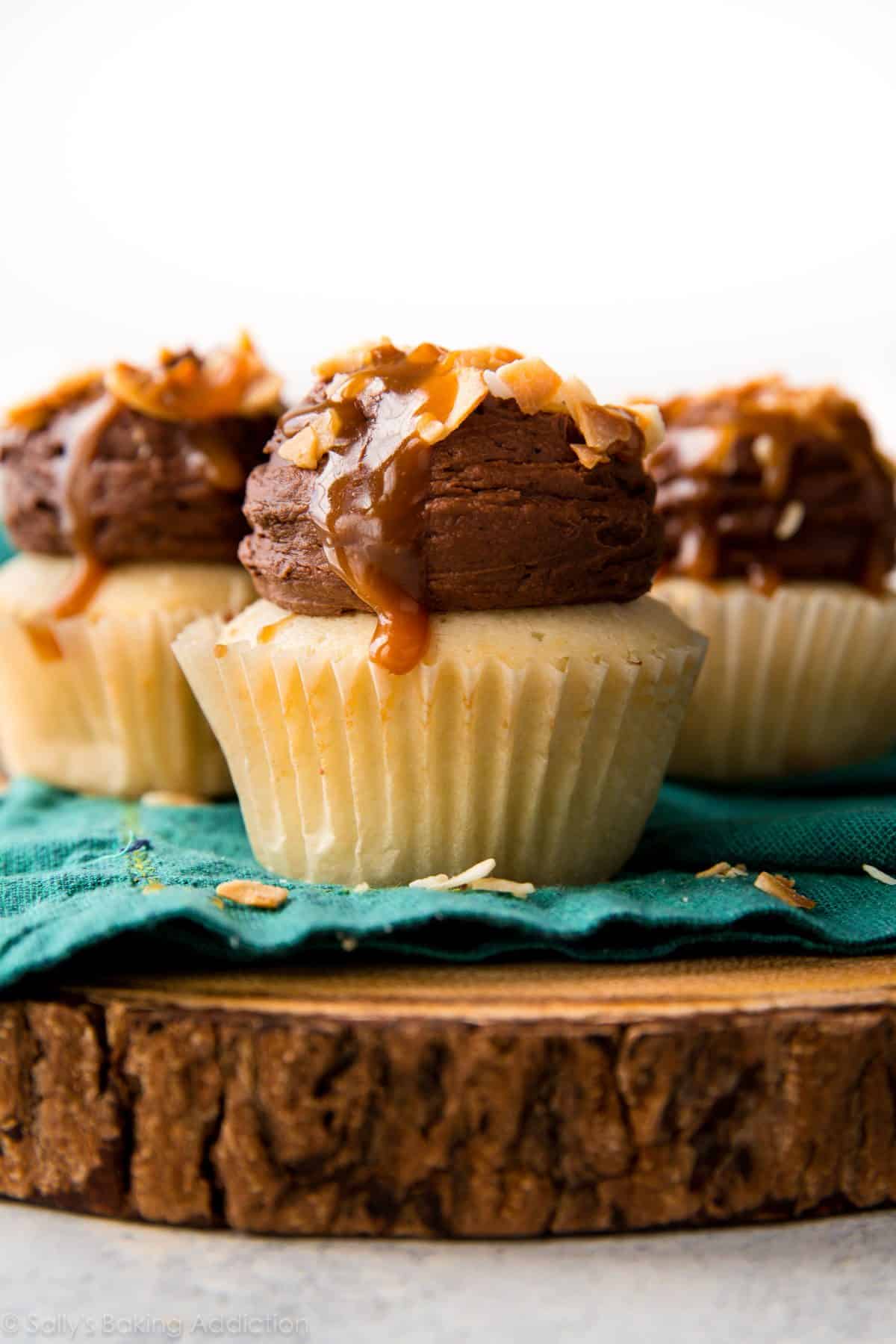 chocolate caramel coconut cupcakes on a wood slice serving board