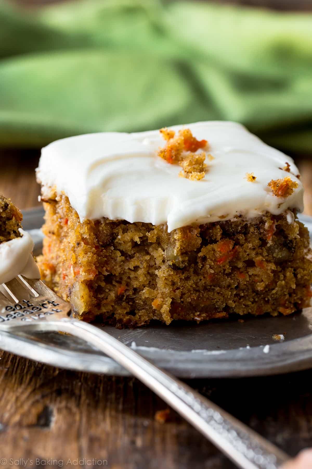 slice of pineapple carrot cake on a silver plate with a fork