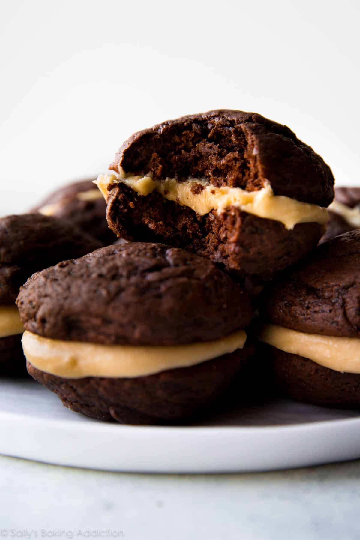 chocolate whoopie pies with salted caramel frosting on a white plate