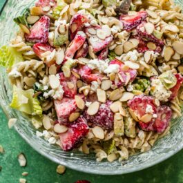strawberry feta pasta salad in a glass bowl