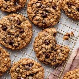 oatmeal chocolate chip cookies on gold cooling rack.