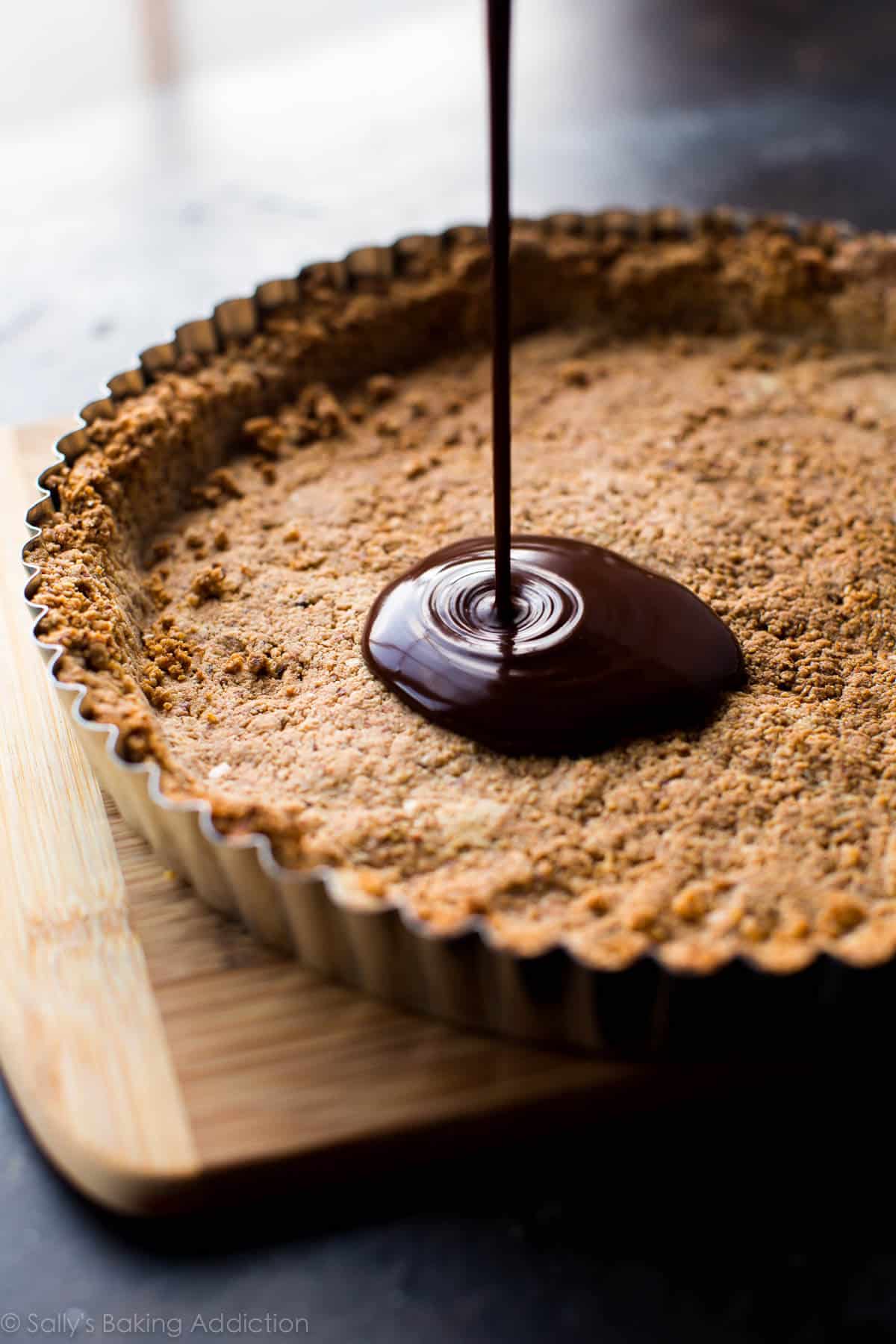 pouring chocolate filling into crust in tart pan