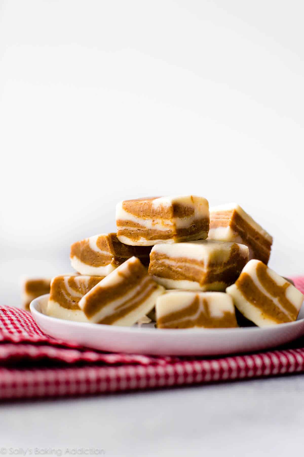 squares of gingerbread fudge stacked onto a white plate