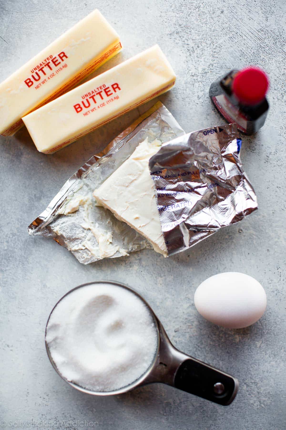 ingredients for soft cream cheese sugar cookies including butter, cream cheese, sugar, egg, and almond extract